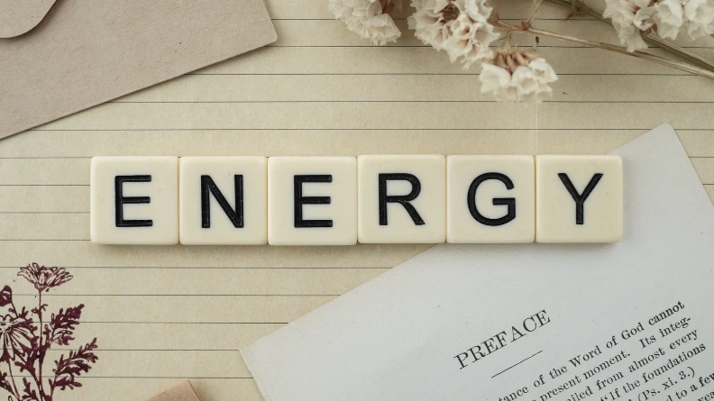 Letter tiles spelling the word energy arranged on an open book.