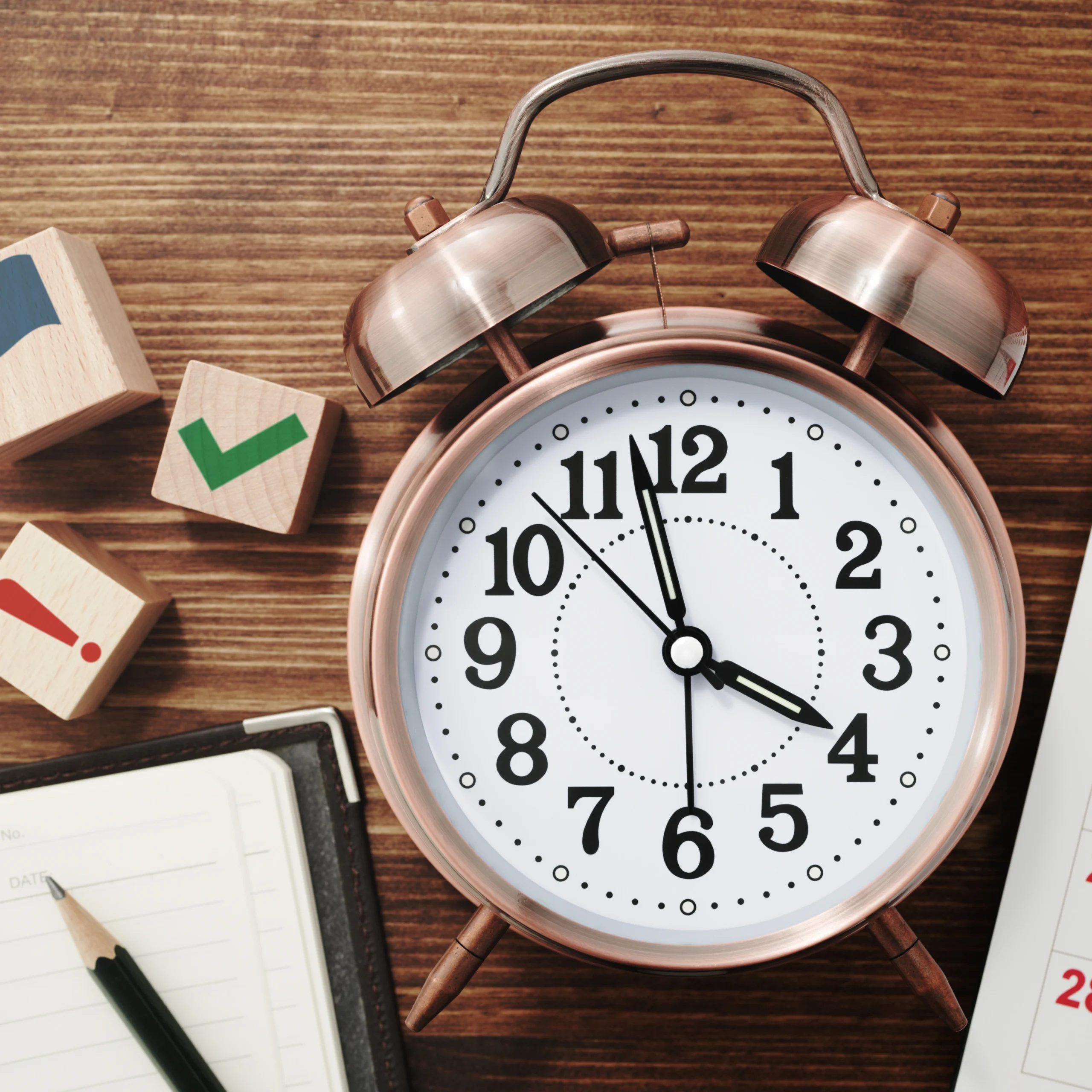 Alarm clock on desk with planner and task symbols. Alarm clock on desk with planner and task symbols.