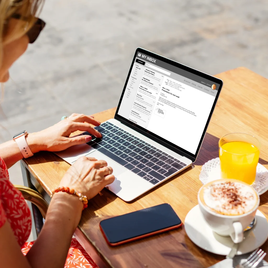 Person working on laptop with coffee at wooden table
